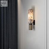 Elegant takah light wall sconce with marble pattern, fluted brass base, and dark metal accents for ambient glow