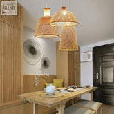Three handcrafted rattan pendant lights with warm natural finish hang above dining table takeh light design