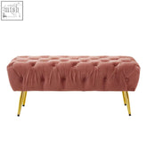 A tamra dusty pink velvet bench with rose-colored tufted velvet and slender gold legs perfect for stylish seating