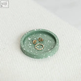 Mint green terrazzo trinket dish with gold toned earrings and ring showing stylish colour combination