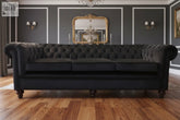 The grande sofa is a black tufted leather chesterfield with rolled arms dark wooden legs and 80cm high frame with high density foam