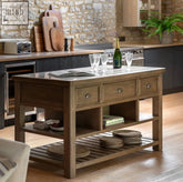 The Hatcliffe kitchen island unit features a rustic wooden base with a polished stone countertop and metal handle drawers d460 x h220mm