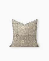 The lyra block print cushion is a square textured throw pillow in muted gray with a subtle floral pattern and gold accents