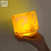 The mystery led cube is a glowing yellow question mark block lamp with a translucent pixelated body perfect as a night light