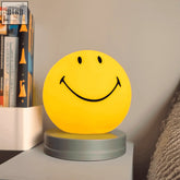 Yellow smiling night lamp with black face, smooth plastic body, metallic base, size 12cm x 12cm perfect for bedrooms