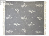 Gray merino lambswool throw blanket with white thistle and bee patterns and fringed edges for cozy use
