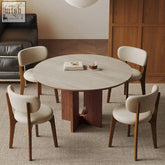 Toure round dining table with light gray marble top and dark wood base in an elegant modern design