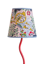 Tree of life lampshade with a vibrant red curved lamp base and a conical shade featuring colorful floral and bird motifs