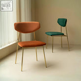 Modern urban dining chair with sleek gold metal frame and rich velvety orange velvet upholstery