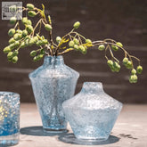 A translucent blue mouth blown glass vase from the dutz collection with a crackled surface and duyz logo