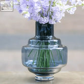 A sleek tiered glass vase in nightblue mouth blown glass from the dutz collection with the dutz logo on its neck