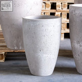 Gray vessara planter made of pigmented concrete with truffle finish in a tapered cylindrical shape for indoor plants