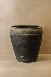 Vintage black asian ceramic pot with weathered dark gray finish and decorative geometric band around the rim