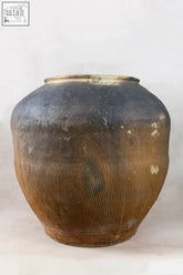 A vintage dark brown ceramic pot xl with a weathered glaze and subtle vertical ridges perfect for rural china decor