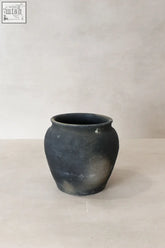 A matte black vintage dark earthenware pot with rounded body and flared rim from shanxi province