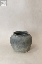 A vintage dark earthenware pot with a matte gray finish rounded body and subtle texture variations