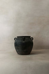 Vintage dark ceramic pot with matte finish and two looped handles featuring a central ridge for decoration