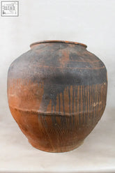 A vintage dark pot xl number 8 with a rustic terracotta body featuring black and reddish brown clay bands and incised lines