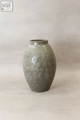 A matte green ceramic vintage glazed yunnan pot with subtle spiral pattern showcasing chinese antique style