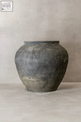 A vintage textured grey ceramic jar with a rounded body and horizontal ribbed texture perfect for decor