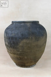 Vintage textured grey ceramic jar with horizontal ridges and earthy patina perfect for rustic decor