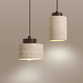 Two cylindrical natural stone pendant lights with dark wood accents and warm led bulb illumination in japanese modern style