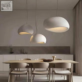 Three matte white wabi sabi pendant lights with organic cloud shapes hanging above a dining table