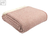 A soft dusky pink waffle knit pure new wool throw blanket with cream fringe perfect for cozy blanket size guide