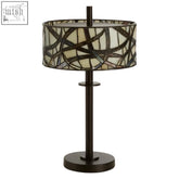 Waldorf branch table lamp with dark bronze metal base and cylindrical cream stained glass shade with black geometric patterns
