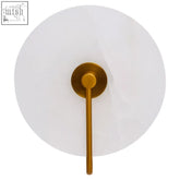 Gold-toned waldorf white marble wall light with circular frosted glass shade and slender stem on marble wall