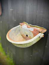 Rusty weathered galvanised metal cattle feeder with faded green and white exterior perfect as wall planters or herb planter