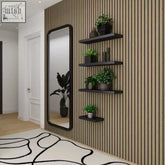 Black floating shelves with potted plants mounted on walnut acoustic wall panels made of wood paneling