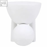 White ceramic wall sconce with rounded bowl top and spherical base paired with whitewash mango wood side table