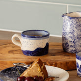Wave ceramic espresso cup with hand painted dark blue wave design on speckled white and blue ceramic mug