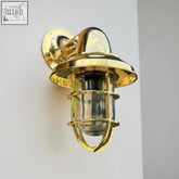 Brass nautical style solid brass wall light with clear glass and protective cage for outdoor and bathroom use