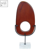 Rich mahogany rich westo natural wood vertical sculpture with circular cutout on black metal stand and travertine base