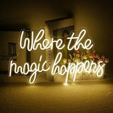 A glowing white led neon sign with the phrase where the magic happens in cursive script for wall decor and gifts