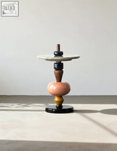 Whimsy round side table with sculptural details and solid wood geometric tiers in peach mustard navy and dark wood tones