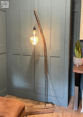 Rustic wooden whiskey stave floor lamp with glowing bulb and curved top made from reclaimed oak current lead time shown