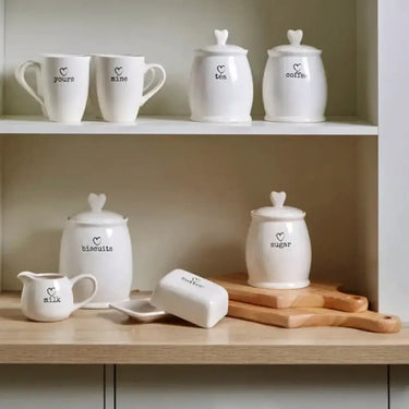 White dolomite sugar canister set with heart-shaped lids and black printed labels for charming kitchen storage