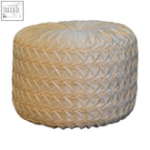Cream-colored woven pouf with textured interlaced pattern perfect as a white hart footstool for cozy seating