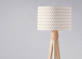 Minimalist tripod floor lamp with white fabric shade featuring copper lines and natural wood base for table lamp use with inch diameter