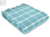 Soft teal and white windowpane pure new wool throw with textured weave and fringed edges perfect for a bed runner