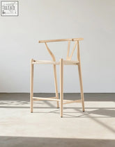 Minimalist wishbone bar stool natural ash with y-shaped backrest and slender legs made of light wood