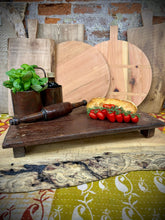 Dark brown wooden pata board with rustic handcrafted look and small feet perfect for pizza and antipasti display