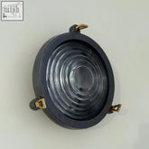Black industrial-style cast aluminium wall light with brass mounting hardware for coastal spec light use