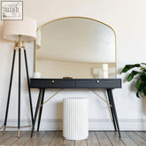 Black console table with gold-tone legs and drawer pulls under a gold metal gentle arch mirror yoko 95cm x 120cm