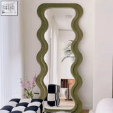 Olive green yuzo mirror with a wavy frame and plush upholstered border adding artistic flair to any room