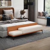 Modern yvonne bench with tan leather frame and white cushioned seating at the foot of a bed