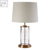 Zella table lamp with clear glass base wirework and gold table lamp accents topped with off-white shade